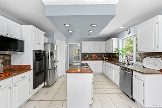 kitchen with butcher block counters, sink, tasteful backsplash, white cabinetry, and stainless steel appliances