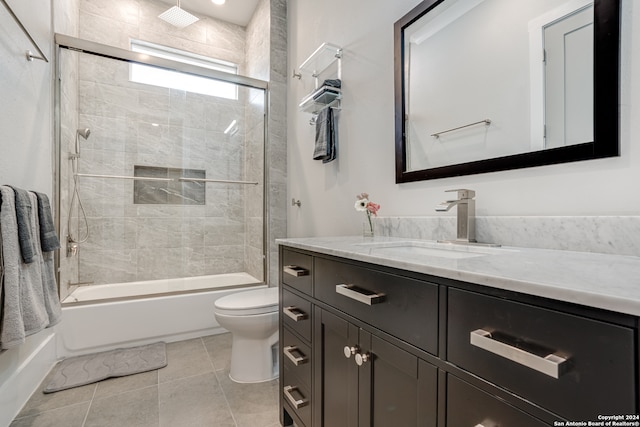 full bathroom with tile patterned flooring, vanity, tiled shower / bath combo, and toilet