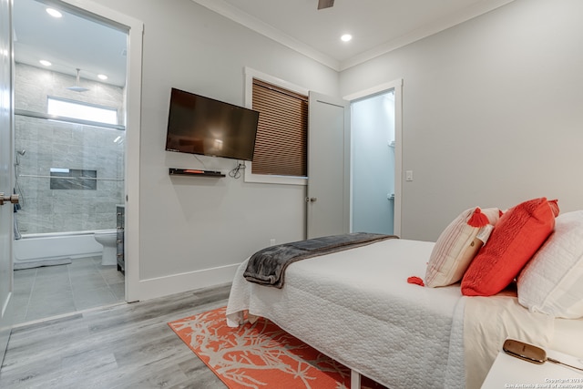 bedroom with ensuite bathroom, crown molding, and light hardwood / wood-style flooring