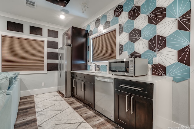 kitchen featuring appliances with stainless steel finishes, dark brown cabinetry, and light hardwood / wood-style floors