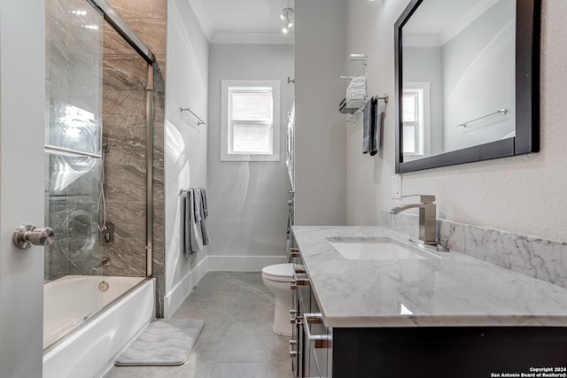 full bathroom featuring tile patterned floors, bath / shower combo with glass door, toilet, vanity, and ornamental molding