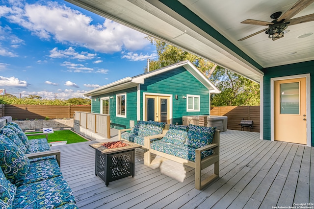 wooden deck with an outdoor living space with a fire pit and ceiling fan