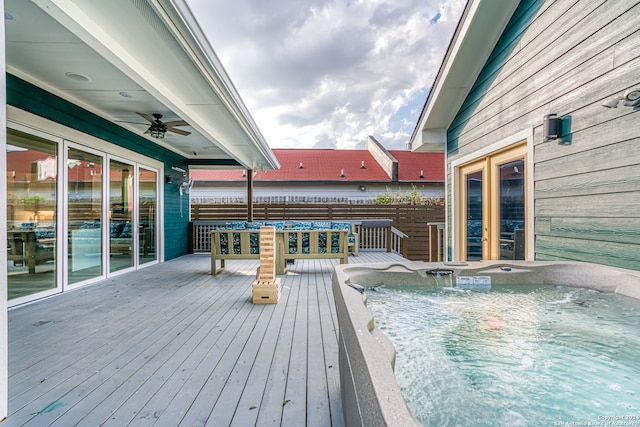 wooden terrace with an outdoor hot tub and ceiling fan