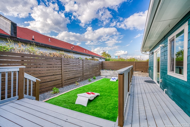 wooden terrace featuring a lawn