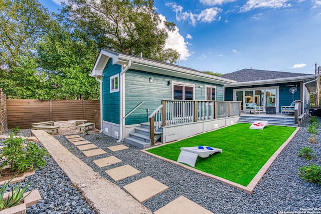 rear view of property with a lawn and a deck