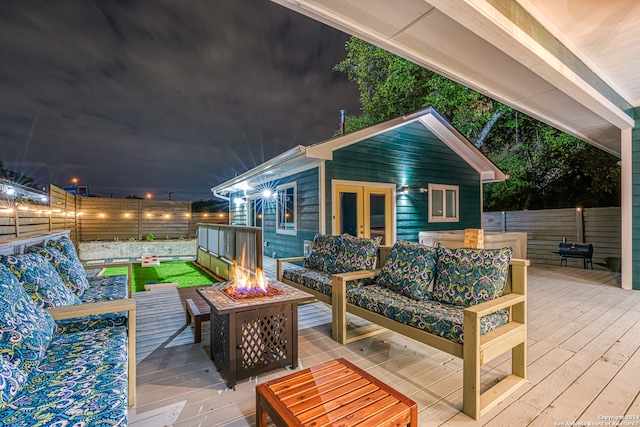 deck featuring french doors and an outdoor living space with a fire pit