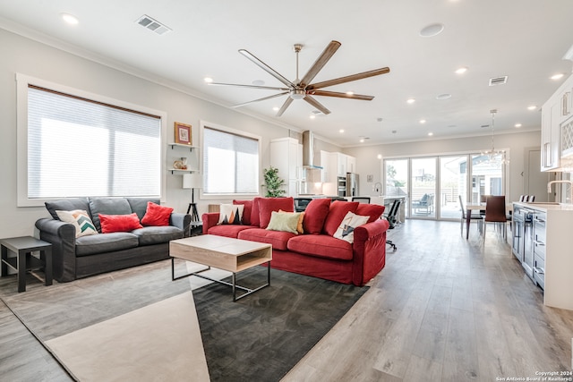 living room featuring light hardwood / wood-style floors, ceiling fan, and ornamental molding