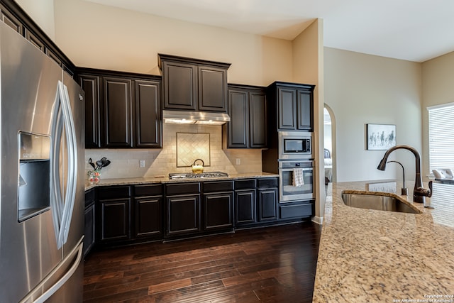 kitchen with dark hardwood / wood-style flooring, light stone countertops, sink, and appliances with stainless steel finishes