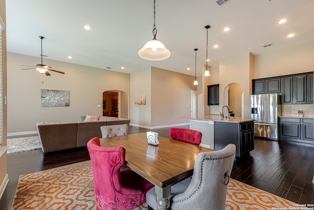 dining room with ceiling fan, sink, and dark wood-type flooring