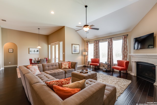 living room with lofted ceiling, ceiling fan, and dark wood-type flooring