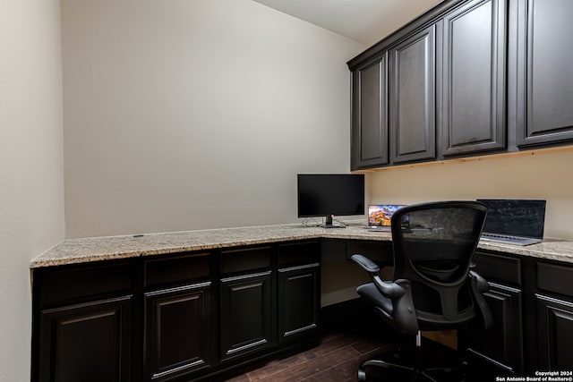 office space with built in desk and dark wood-type flooring