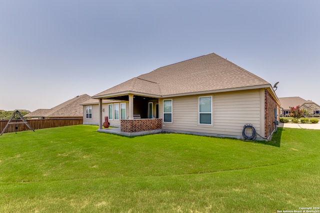 rear view of property with a lawn