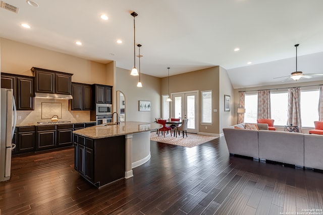 kitchen featuring dark wood-type flooring, a kitchen island with sink, hanging light fixtures, and stainless steel appliances