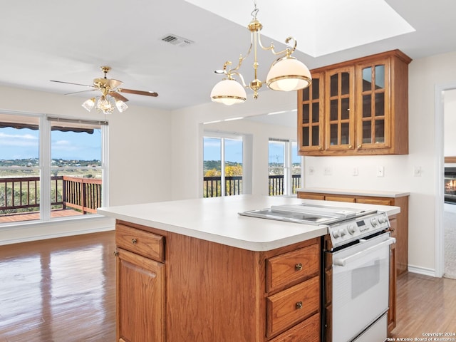 kitchen with white electric range oven, light hardwood / wood-style floors, hanging light fixtures, and ceiling fan with notable chandelier