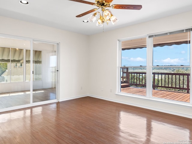 empty room with hardwood / wood-style flooring, a wealth of natural light, and ceiling fan