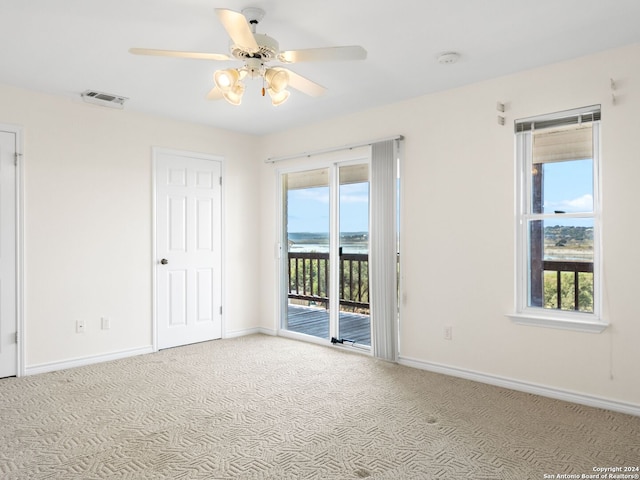 spare room featuring light colored carpet and ceiling fan