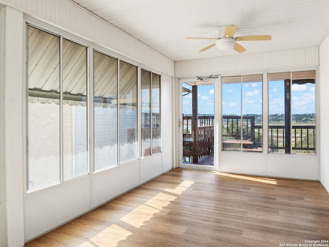 unfurnished sunroom with ceiling fan