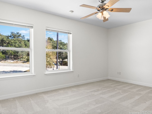 empty room featuring light colored carpet and ceiling fan