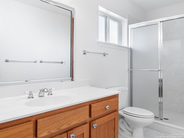 bathroom featuring vanity, toilet, and an enclosed shower