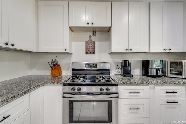 kitchen featuring white cabinets, light stone countertops, and stainless steel range with gas stovetop