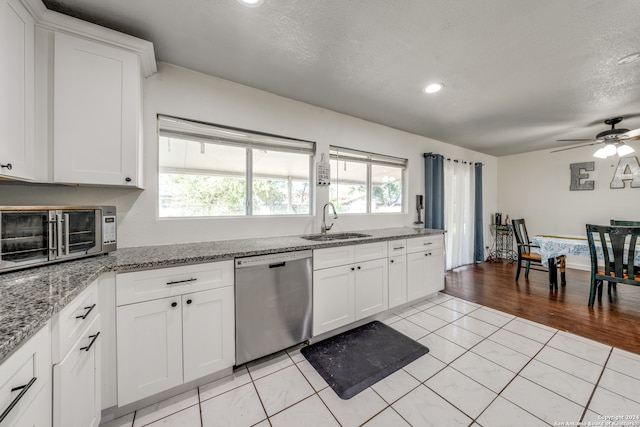 kitchen with dishwasher, white cabinets, and ceiling fan