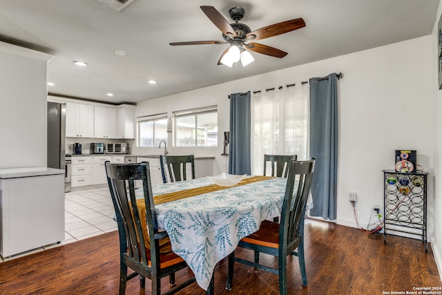 dining space with ceiling fan, light hardwood / wood-style flooring, and sink