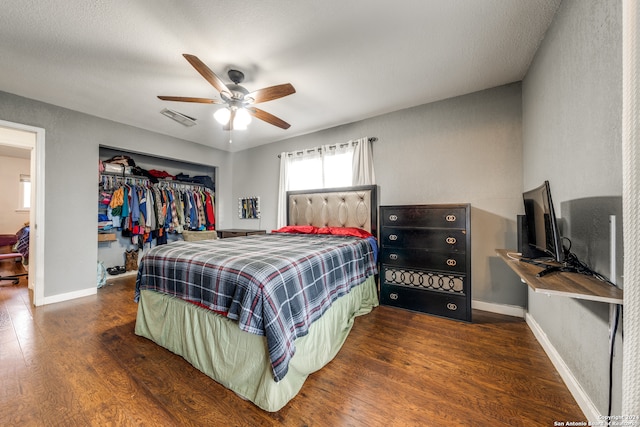 bedroom featuring dark hardwood / wood-style floors, ceiling fan, a textured ceiling, and a closet