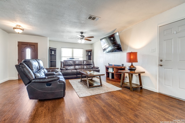 living room with ceiling fan, dark hardwood / wood-style flooring, and a textured ceiling