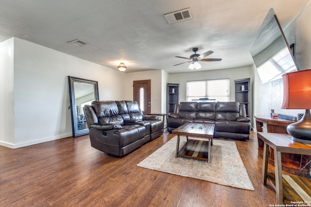 living room featuring a textured ceiling, ceiling fan, and dark hardwood / wood-style floors