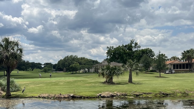 view of home's community featuring a water view and a lawn