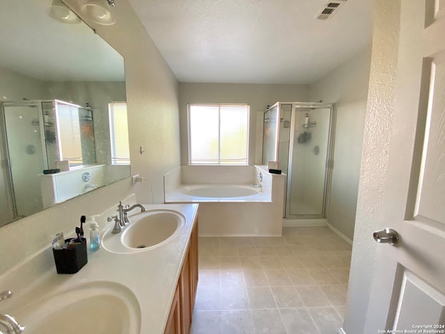 bathroom featuring separate shower and tub, vanity, and a textured ceiling