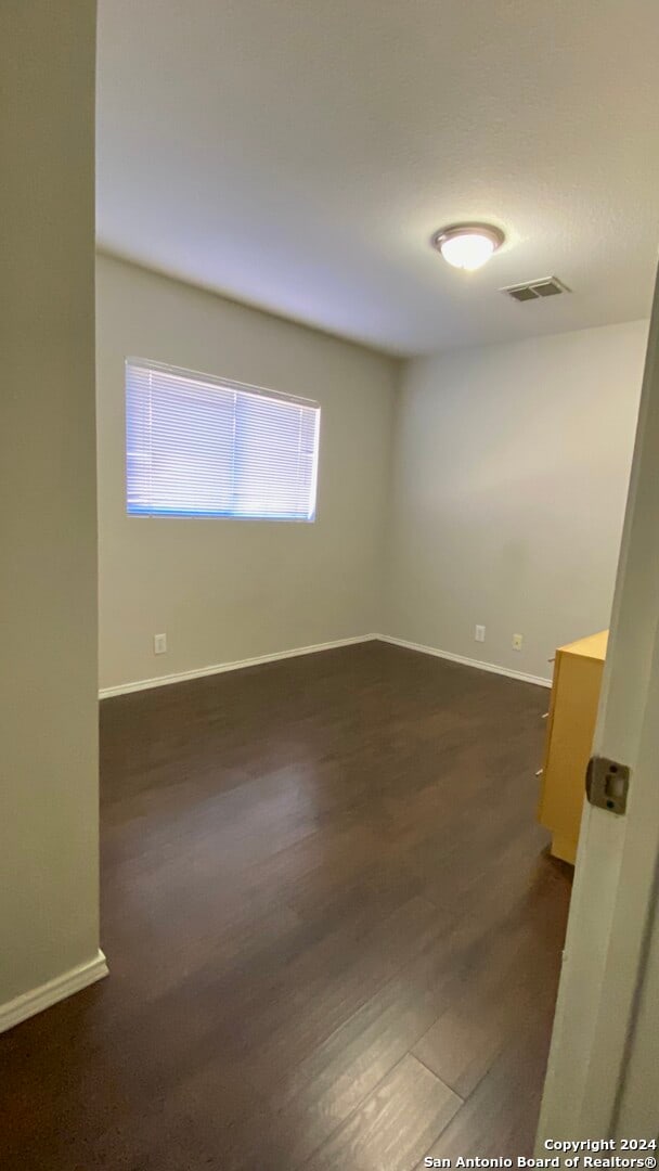 empty room with dark hardwood / wood-style flooring