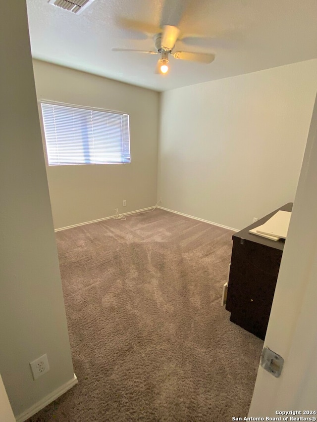 unfurnished room featuring ceiling fan and carpet