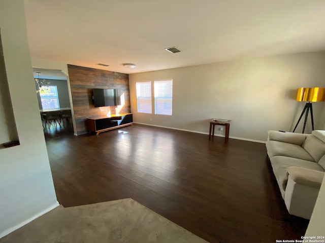 unfurnished living room featuring dark hardwood / wood-style floors and an inviting chandelier