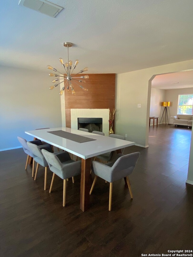 dining space featuring dark hardwood / wood-style flooring and a chandelier