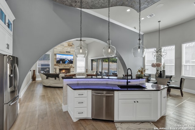 kitchen featuring white cabinets, a stone fireplace, sink, and appliances with stainless steel finishes