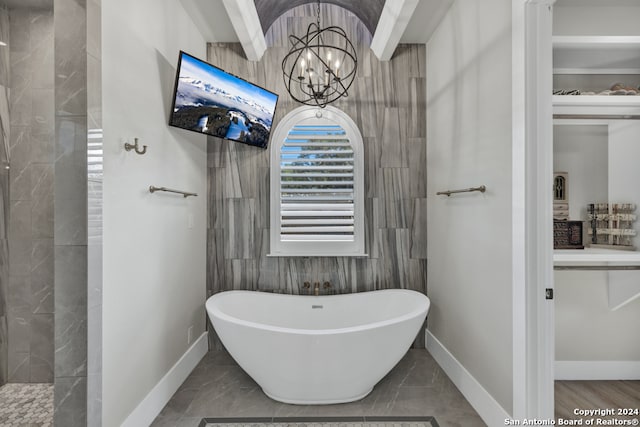 bathroom with a bathing tub and an inviting chandelier