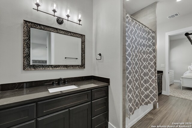 bathroom with vanity, hardwood / wood-style flooring, and curtained shower