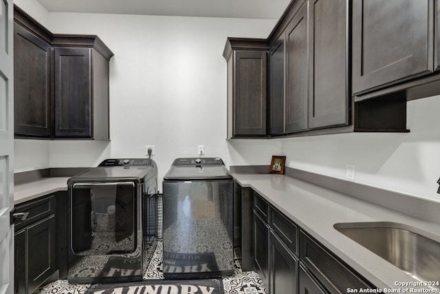 washroom featuring washing machine and dryer, sink, and cabinets