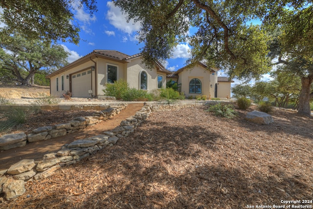 mediterranean / spanish home with a garage