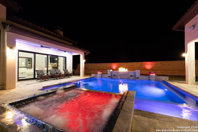 view of swimming pool featuring outdoor lounge area, pool water feature, a patio area, and an in ground hot tub