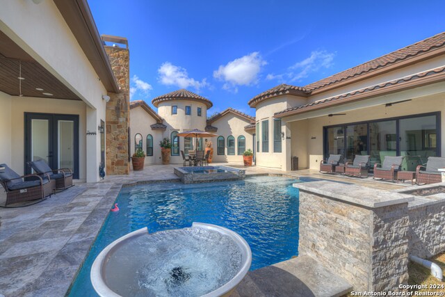 view of swimming pool featuring ceiling fan, an in ground hot tub, and a patio