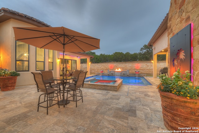 view of swimming pool with pool water feature, an in ground hot tub, and a patio