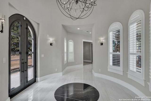 entrance foyer featuring a chandelier and french doors