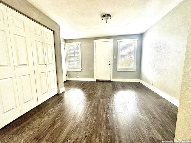 foyer entrance with a textured ceiling and dark hardwood / wood-style floors