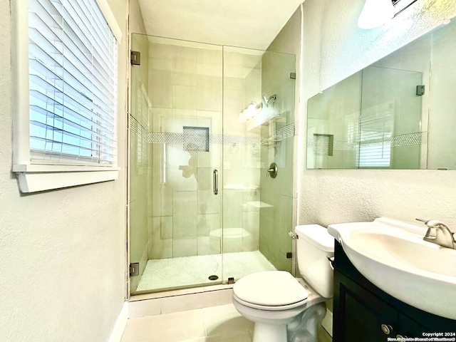 bathroom with tile patterned flooring, vanity, an enclosed shower, and toilet