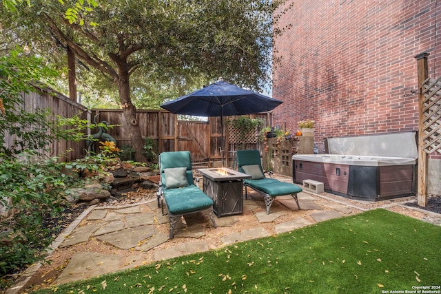 view of patio featuring a hot tub and a fire pit