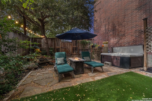 view of patio featuring a hot tub and an outdoor fire pit