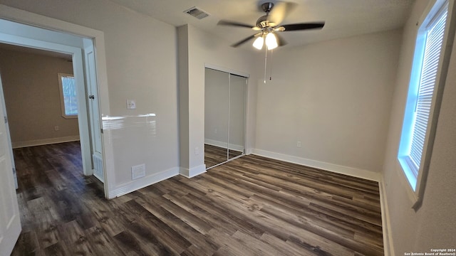 unfurnished bedroom featuring dark hardwood / wood-style flooring, a closet, and ceiling fan