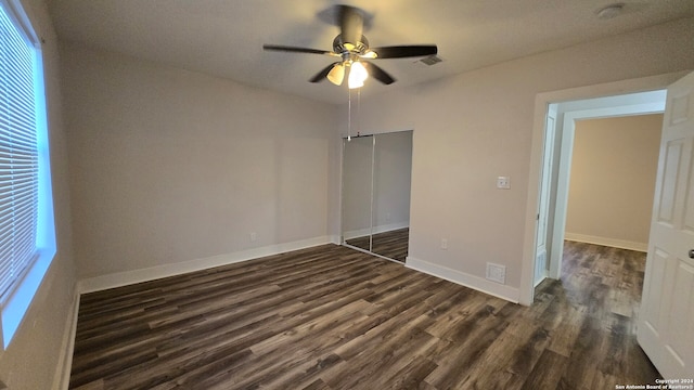 unfurnished bedroom with a closet, ceiling fan, and dark wood-type flooring